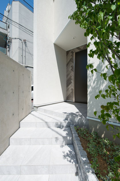 外壁に木目調タイルを使ったおしゃれなデザインの二世帯住宅のアプローチ