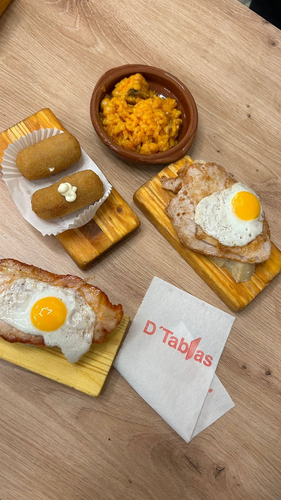 Verschiedenste Tapas wie Patatas bravas, Paella und Brötchen mit Steak und Spiegelei