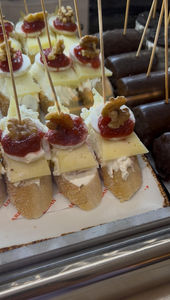 leckere Tapas mit Frischkäse, Käse, Marmalade und einer Wallnuss mit einem Spieß darauf