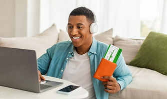 cheerful-young-black-man-denim-wireless-headphones-preparing-trip-holding-tickets-passport