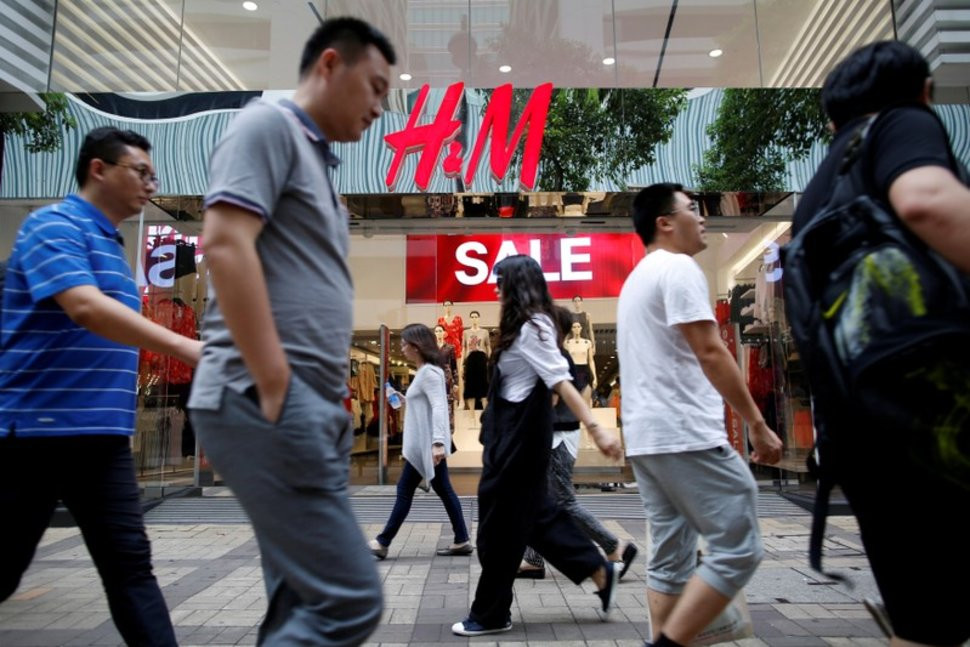 FILE PHOTO: People walk past a H&M fashion chain store at Tsim Sha Tsui shopping district in Hong Kong, China August 1, 2016. REUTERS/Tyrone Siu/File Photo