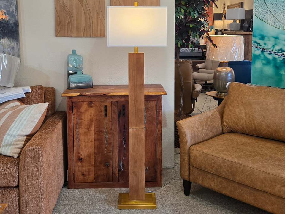 Tall wooden floor lamp with a white rectangular lampshade in a cozy living room setting.