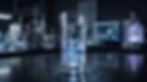 Glass of water with blue swirling light on a lab bench, with blurred lab equipment in the dark background.