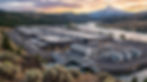 Industrial power plant by a river at sunset, with snowcapped mountain, forested hills, and visible U-4 markings.