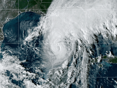Satellite view of a swirling hurricane (Isaias) over the Gulf of Mexico, with dense white clouds near Texas and Mexico.