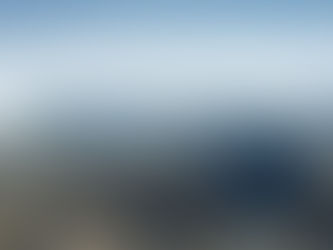 A vast landscape features rugged brown mountains and a deep canyon, bordered by a massive ice sheet under a clear blue sky.