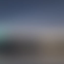 A bright comet streaks across a starry sky above a tranquil lake and mountain silhouette at dusk, reflecting vivid colors in the water.