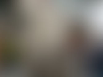 Workers remove "USAID" letters from a building wall. Scaffolding and flags visible, with people conversing nearby. Capitol in background.