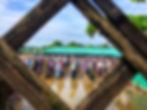 Worshippers gather for communal prayer in the camp, reflected in rainwater left after rainfall. 2026 © Ayub Khan