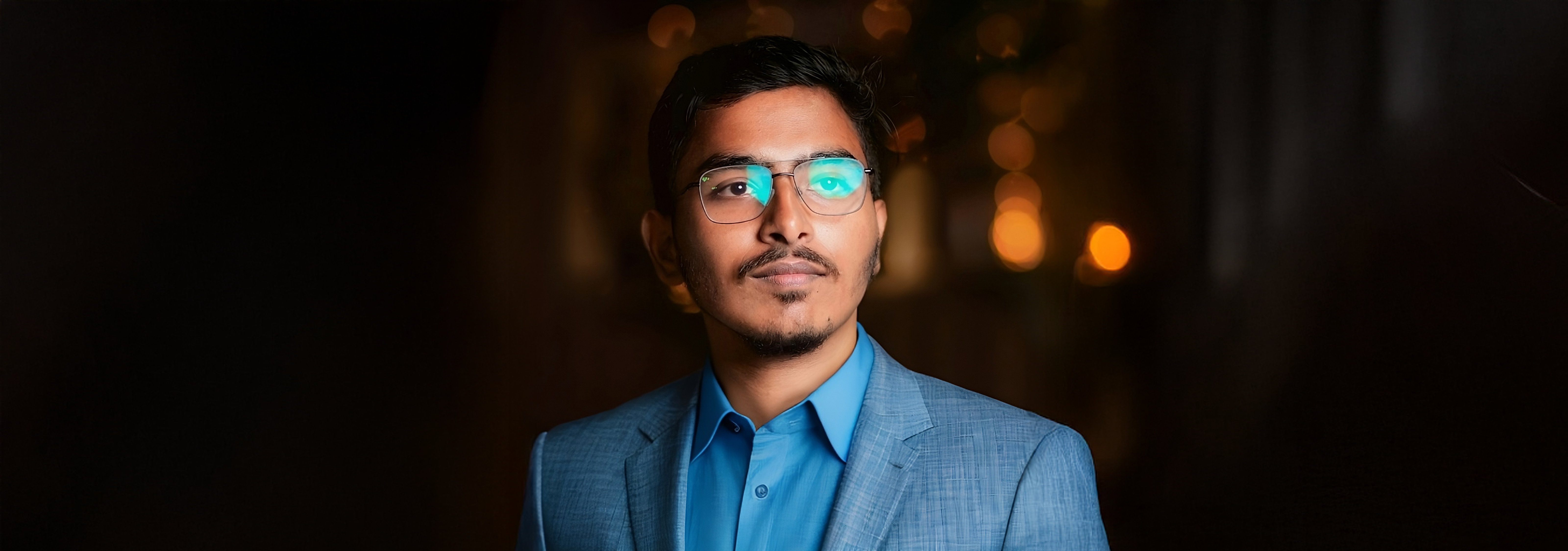 A photo of Shyama Dash in a suit over a blurry background