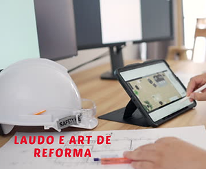 Mesa de trabalho de engenharia com capacete branco, tablet e planta arquitetônica, ilustrando o planejamento técnico para emissão de Laudo de Imediações e ART de Reforma.