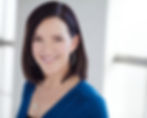 Professional headshot of woman with dark hair in a blue top
