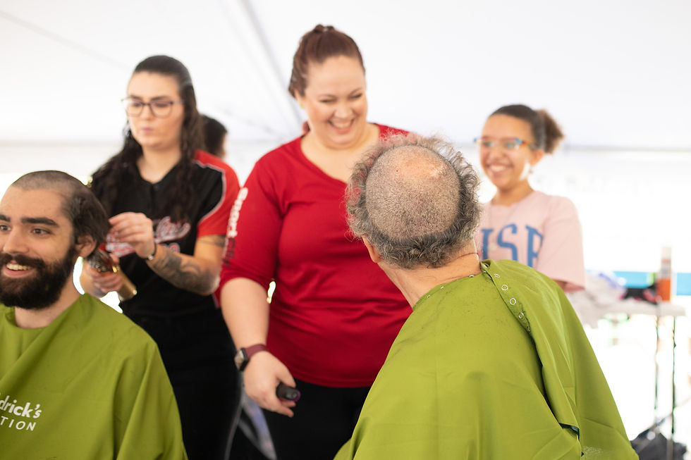 Man shaving head at St. Baldrick's Foundation shaving event to raise money for childhood cancer research.