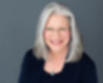 Professional headshot of woman against a dark studio background