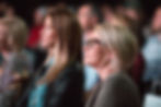 Audience members watching a TED Talk during editorial event coverage