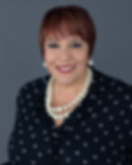 Professional headshot of woman in black against a gray background
