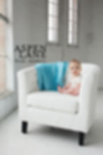 Lifestyle interior photograph featuring a styled home setting with baby model for baby blanket product