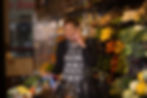Woman grocery shopping while using her phone during a lifestyle photography session