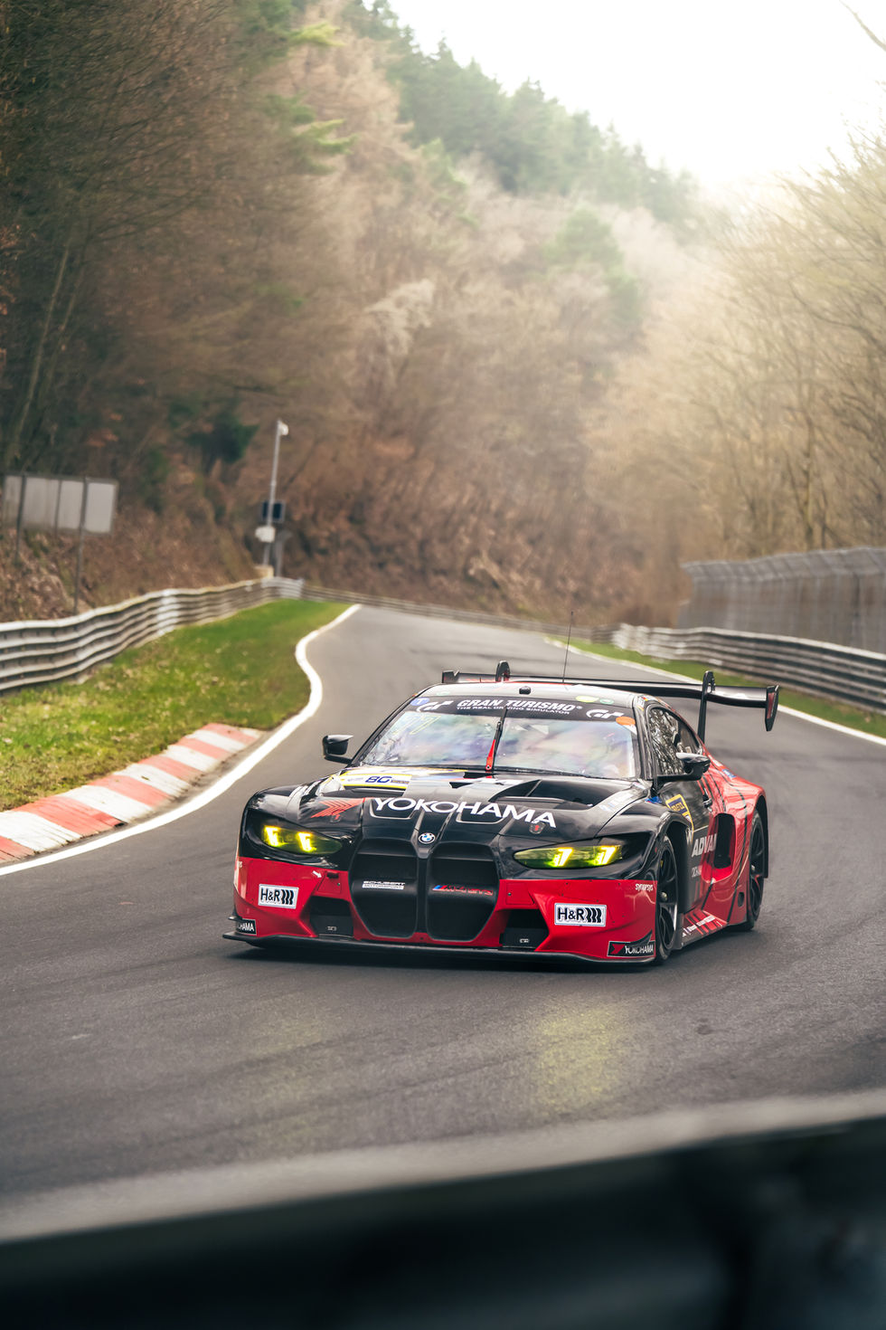 Yokohama's BMW M4 GT3 during NLS race at Nürburgring Nordschleife, taking the corner at Bergwerk in endurance racing.