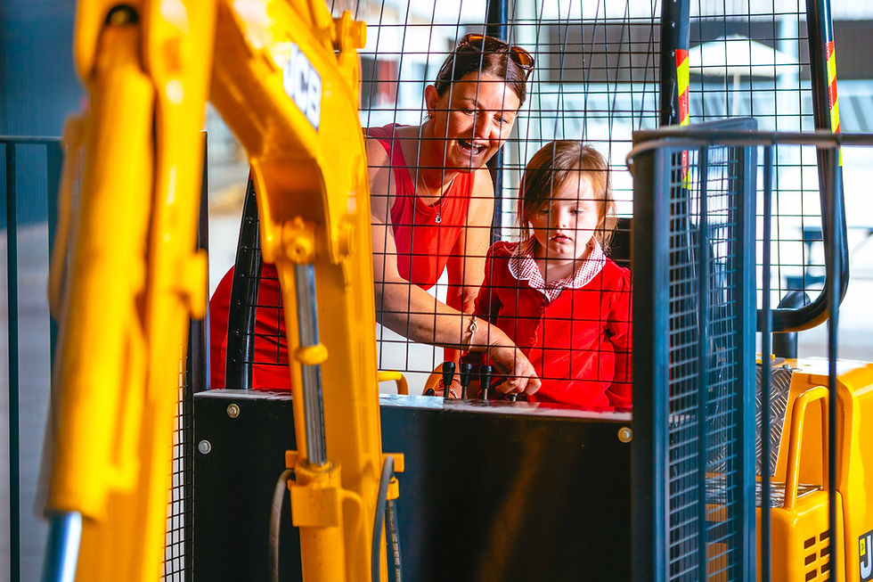 a mom and daughter playing with the digger attraction