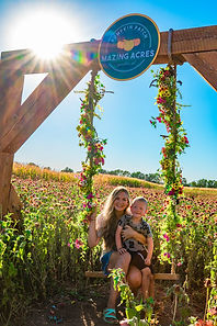 Woman and child on a flowered swing at Mazing Acres.