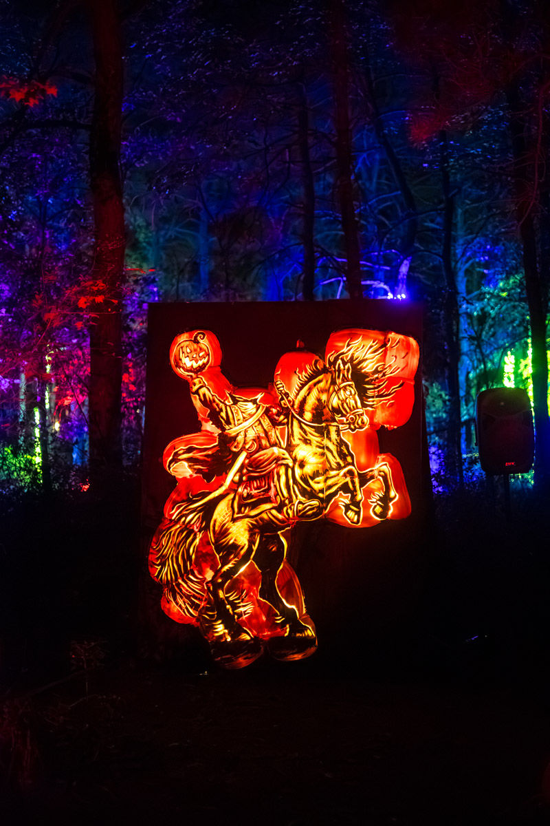 The Headless Horseman pumpkin carving in a dark forest.