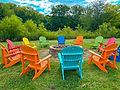 Colorful Adirondack chairs surrounding an outdoor fire pit