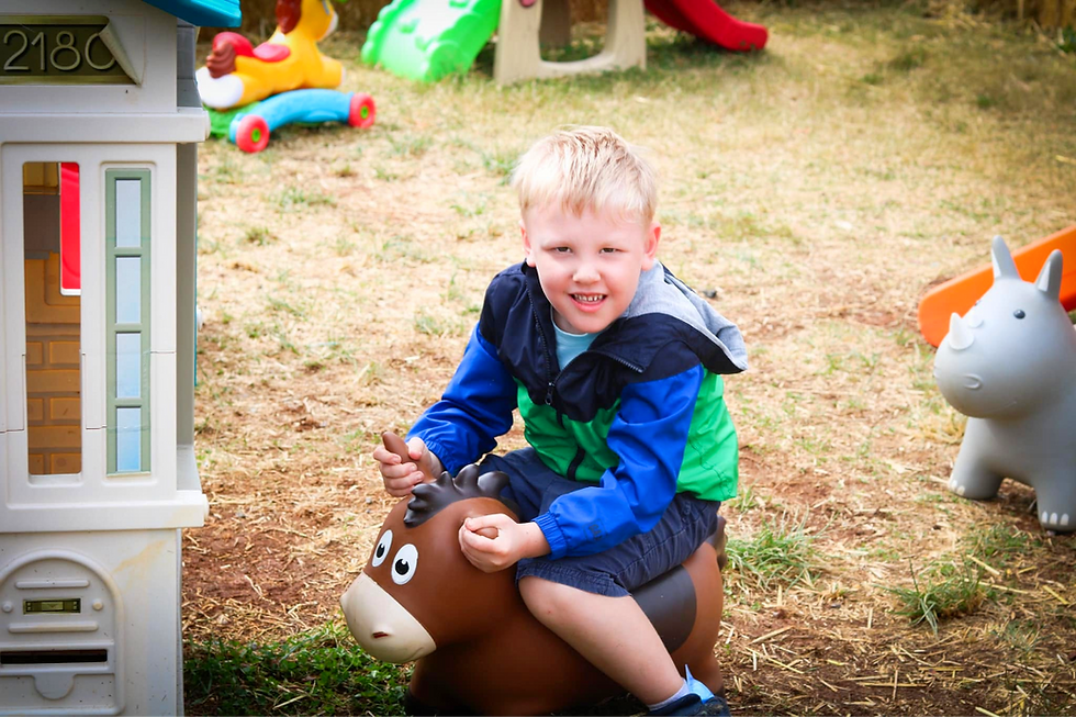 Young boy riding a toy horse at the Fall Festival