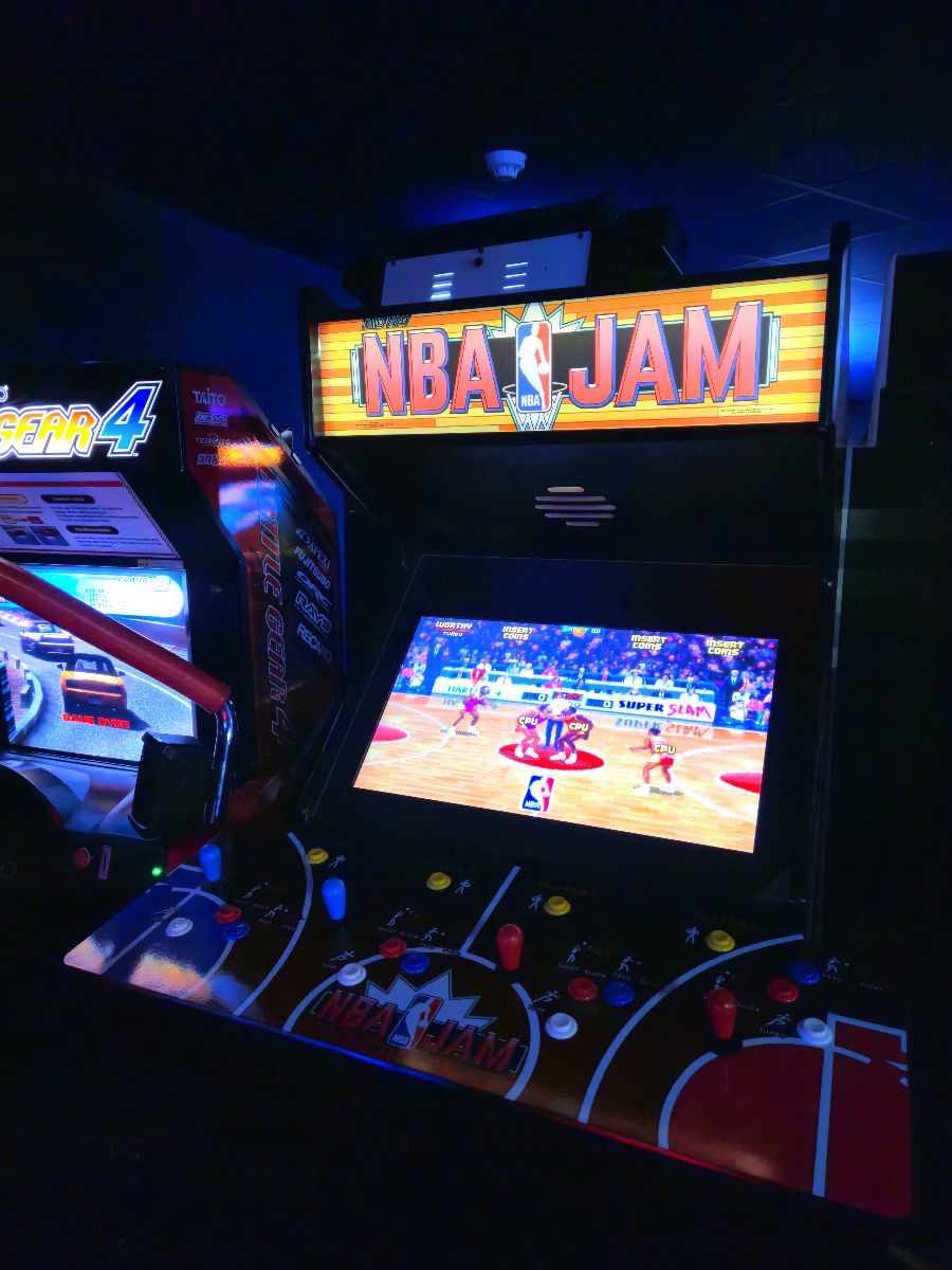 NBA Jam arcade machine in a dimly lit game room