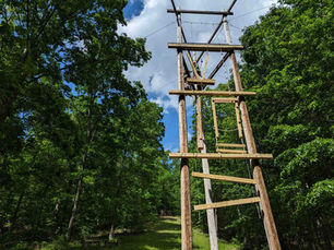 Wooden climbing structure surrounded by dense green forest, part of an outdoor adventure area near Smoky Mountain cabin rentals.