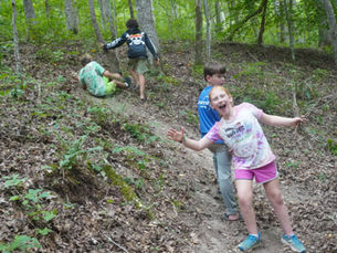 Kids hiking through the woods having fun on a trail at one of the best camping spots in Tennessee.