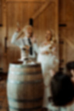 Bride and groom sharing a toast with champagne in a rustic barn setting at The Farm Yarra Valley.