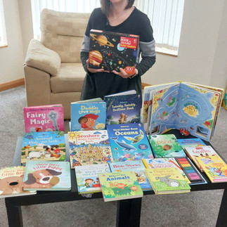 Silvia Pontes standing behind a table displaying Usborne Children's books