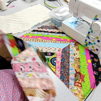 sewing machine in action with multicoloured fabric quilted