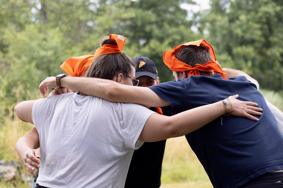 Groupe de collègues unis se tenant en cercle pour se motiver avec un cri de guerre avant un jeu d’équipe