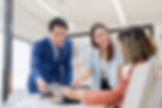 Three people in an office talking about a project
