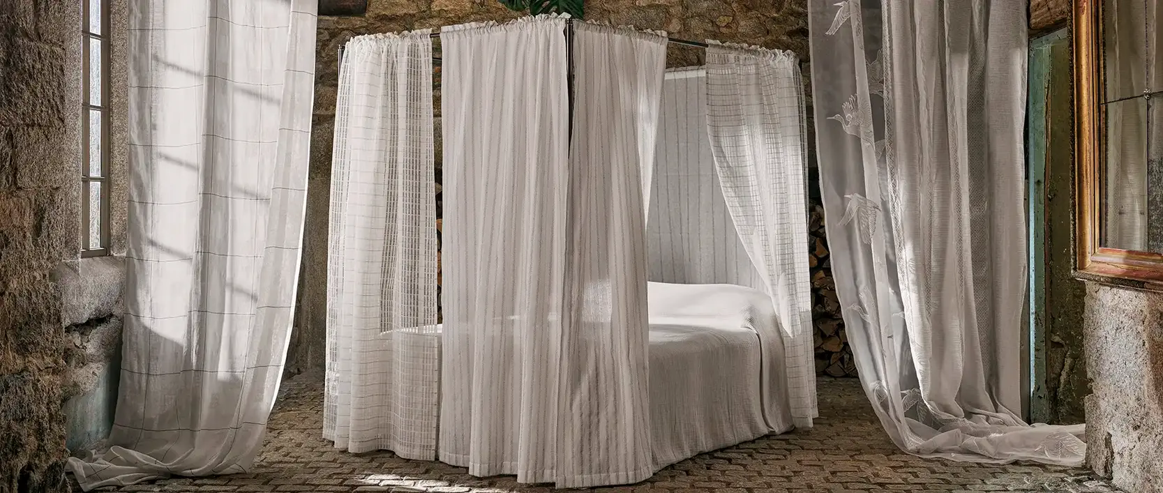 A selection of luxruy fabrics from the Sheers collection by Sanderson_ss26_draped in a bedroom