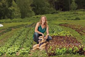 Acadia Tucker sitting on a raised bed with a dog