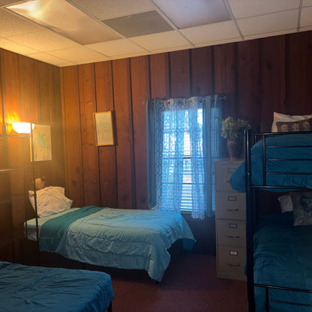 A bedroom inside Compassion’s Foundation’s emergency shelter, furnished with beds and basic necessities for survivors seeking safety.