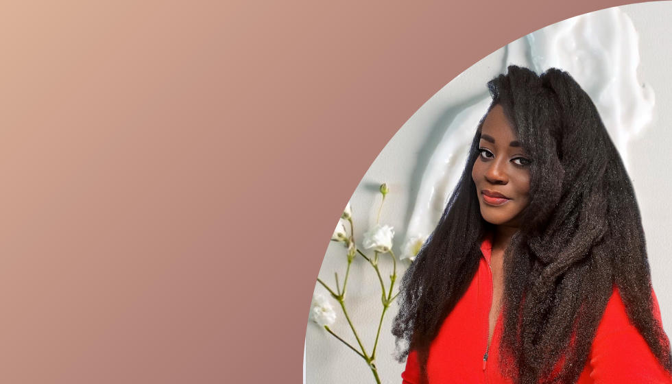 image of a lady with long full natural black hair , and she has a smile.