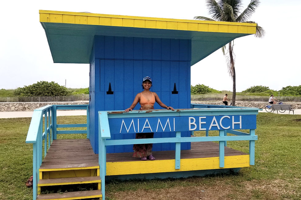 Beneath the vibrant blue and yellow lifeguard hut at Miami Beach, I am here savoring a moment of shade in the sunny surroundings.