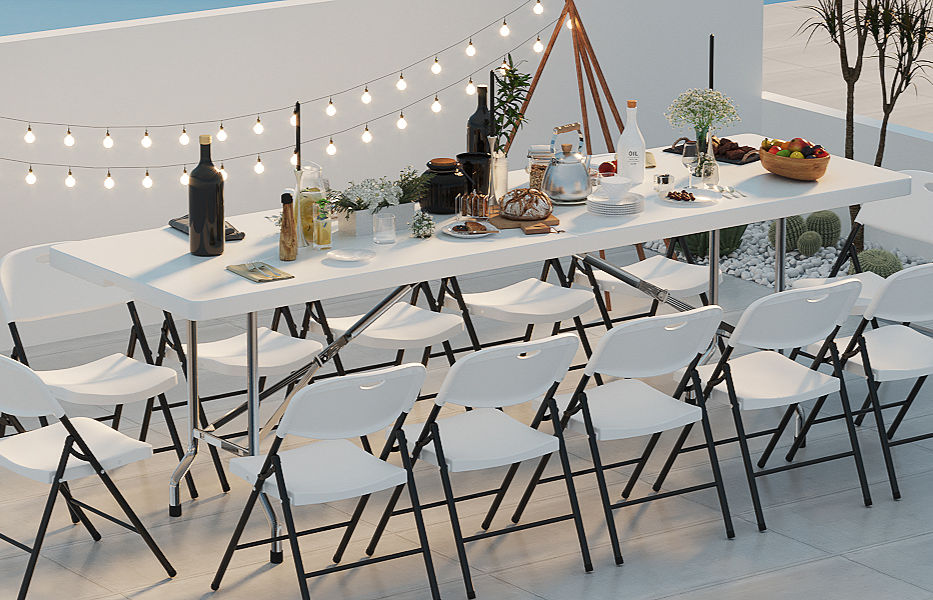 Outdoor party setup with a long white table, chairs, string lights