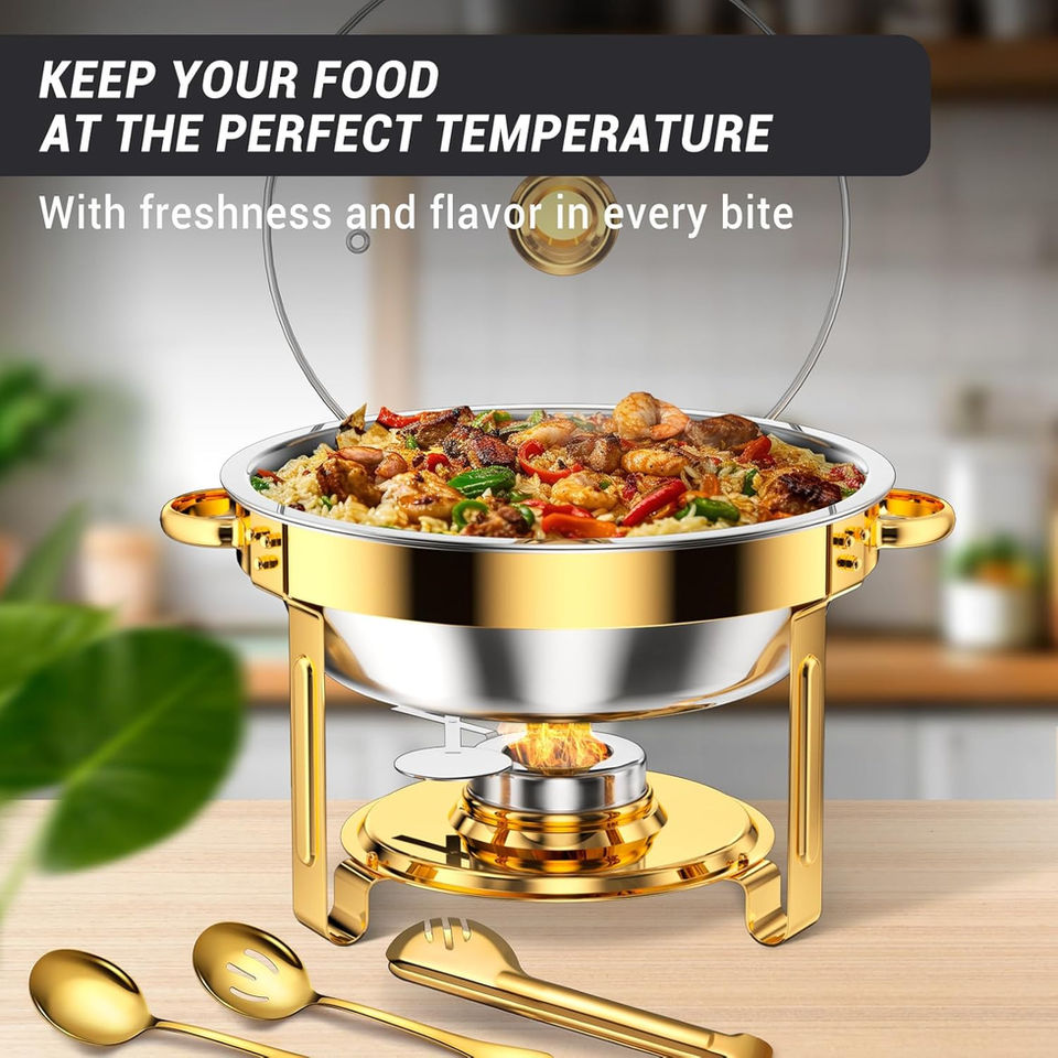 Gold chafing dish with food and glass lid on a table.