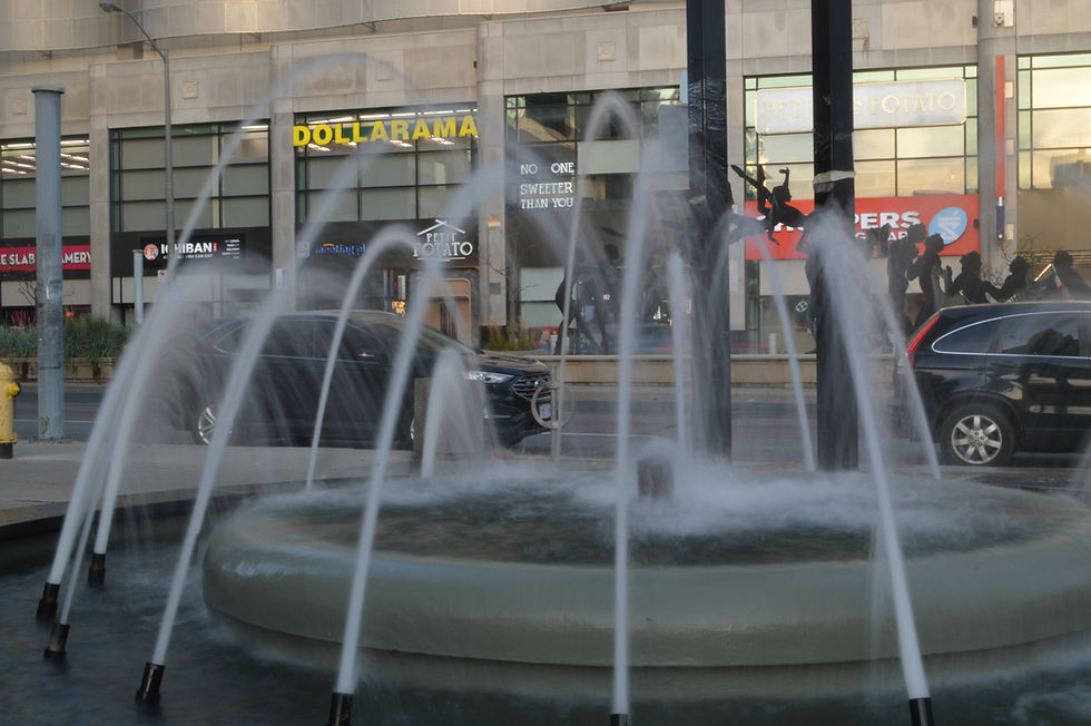 Outdoor fountain in a city plaza with jets of water.