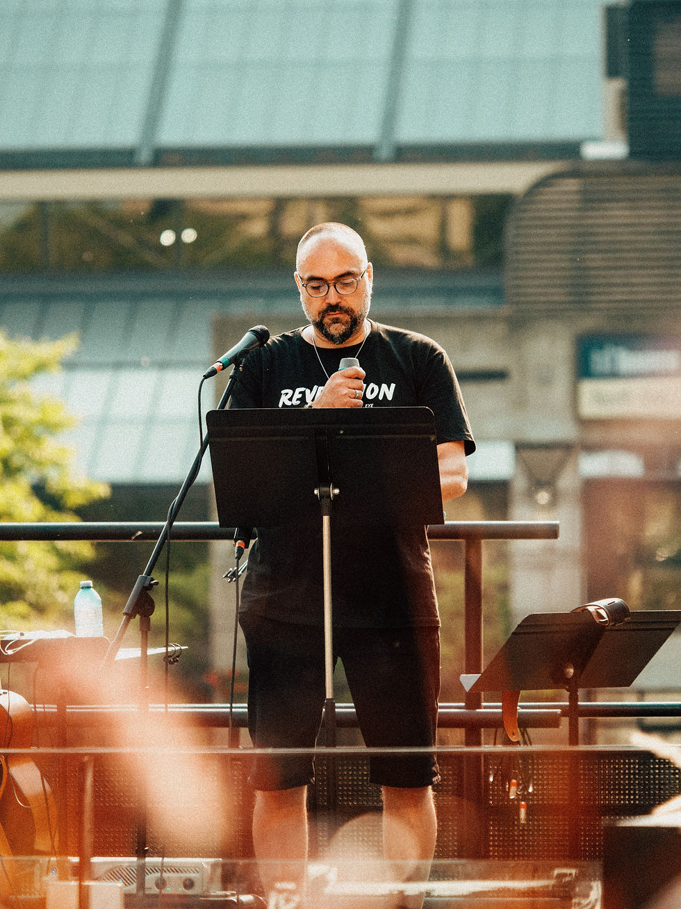 Man speaking at a microphone, the Apple of My Eye.