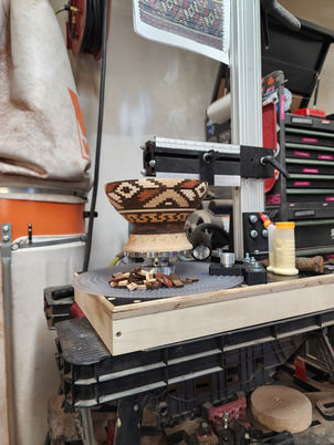 Intricate patterned wooden bowl being crafted on a lathe.