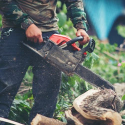 hombre-asiatico-cortando-arboles-usando-