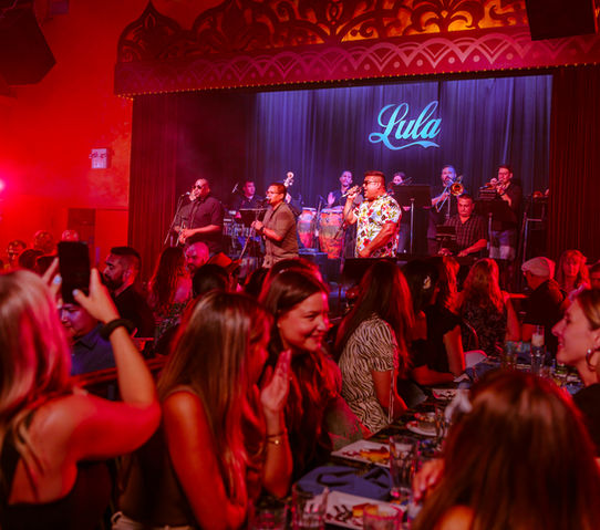 Girls enjoying dinner and having cocktails while watching a concert at Lula Lounge.