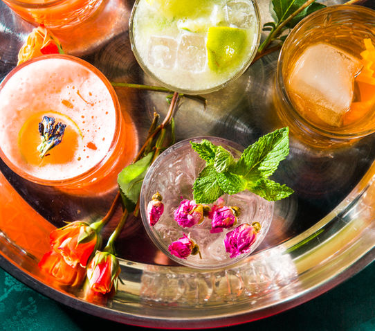 A tray of colourful cocktails at Lula Lounge decorated with edible flowers.