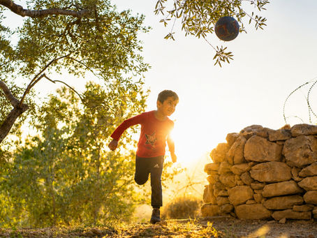 Kinder spielen mit Ball in Bewegung